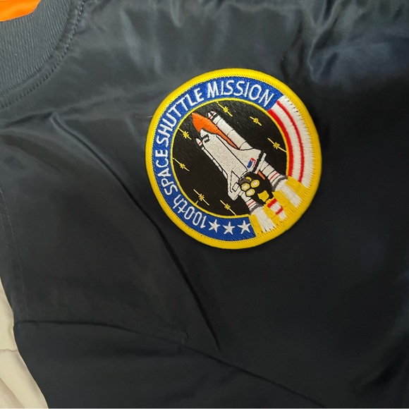 Navy blue bomber jacket With orange inside 
Goes for $300
Flips inside out - Picture 6 of 7